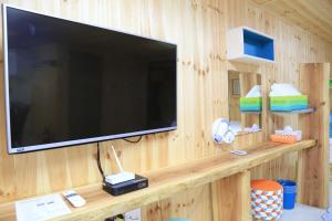 a large flat screen tv on a wooden wall at Jeju Best Hill in Jeju