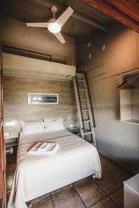 1 dormitorio con 1 cama y ventilador de techo en Pousada Colina Verde, en Garopaba