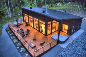 an overhead view of a tiny house with a deck at KALLM-Mont-Tremblant chalet with hot tub, pond & beach on private 7acre estate in Lac-Superieur