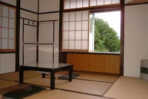 een kamer met een tafel voor een raam bij Lodge Amenouo in Myoko