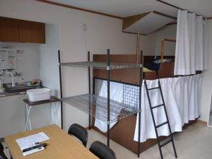 een kamer met een stapelbed met een tafel en een ladder bij コウノトリの里の宿 in Fukiage