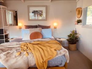 Un dormitorio con una cama con una manta. en Apollo Bay Beach Bungalow - Couples Retreat, en Apollo Bay