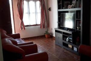 una sala de estar con un sofá y un televisor en La Nona, en El Carmen