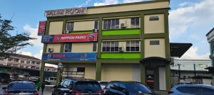 a building with cars parked in front of it at Salim Room in Sibu