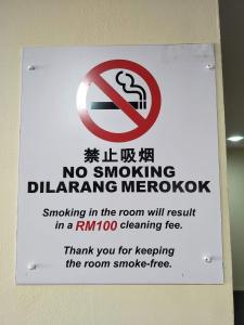 a sign on a wall with a no smoking sign at Salim Room in Sibu