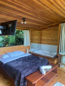 1 dormitorio con 1 cama y TV de pantalla plana en Chalé Silvia Gatto - Suíte Bauru en Núcleo Mauá