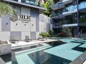 a swimming pool in front of a building at A401-Silk Condo Aonang, Sea view - 5 mins to beach in Krabi