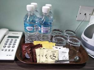 ein Tablett mit Wasserflaschen und Gläsern auf dem Schreibtisch in der Unterkunft Salim Room in Sibu