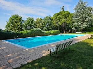 een zwembad met een bank in het gras bij Serene Holiday Home in Lazise with Swimming Pool in Lazise