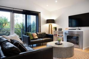 a living room with a couch and a fireplace at Delfryn in Daylesford