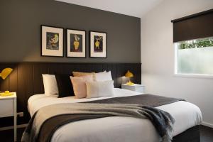 a bedroom with a large bed with four pictures on the wall at Delfryn in Daylesford
