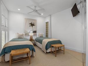 a bedroom with two beds and a tv on the wall at Cotton Beach 94 Mid-Floor Penthouse with Bush View in Casuarina +22 photos