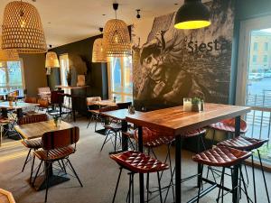 a restaurant with tables and chairs and a large wall at Hotell Siesta in Karlskrona