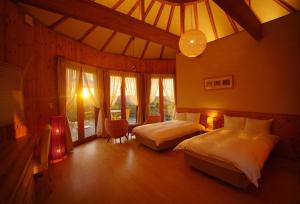 1 Schlafzimmer mit 2 Betten in einem Zimmer mit Fenstern in der Unterkunft GRAND CHARIOT Hokutoshichisei 135° in Awaji
