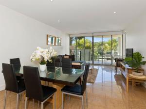 a dining room with a glass table and chairs at Cotton Beach on the Pool 66 in Casuarina