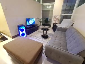 uma sala de estar com um sofá e uma televisão em Serenity Home near Ayala Malls Serin em Tagaytay