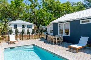 a backyard with a pool and a blue house at 106 the Church St Collection with pool in Fairhope