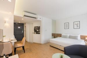 a hotel room with a bed and a table and chairs at Aster Hotel and Residence by At Mind in Pattaya