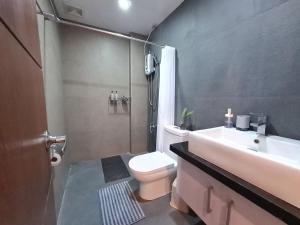 y baño con aseo, lavabo y ducha. en Serenity Home near Ayala Malls Serin en Tagaytay