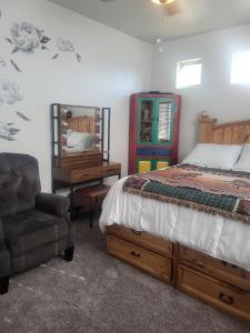 ein Schlafzimmer mit einem Bett, einem Stuhl und einem Schreibtisch in der Unterkunft Cozy Casita Suite in Las Cruces