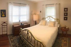 Un dormitorio con una gran cama blanca y una ventana en Cozy Chalet near the Design District, en Miami