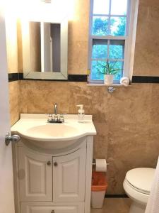 bagno con lavandino, servizi igienici e specchio di Cozy Chalet near the Design District a Miami
