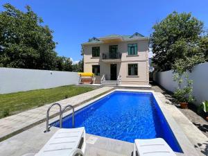 a house with a swimming pool in front of a house at Gabala villa in the center in Gabala