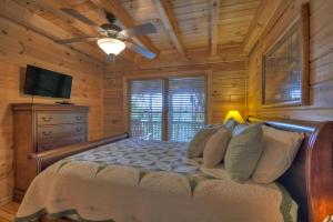 a bedroom with a bed with a ceiling fan and a television at Lofty Vista in Blue Ridge