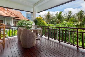 a balcony with chairs and a table and trees at Luxury Danatrip Villas in Da Nang
