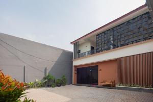 um edifício com uma varanda ao lado em Hanna Residence near RSPI Puri Indah Mitra RedDoorz em Meruya-hilir