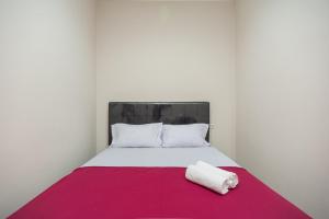 uma cama com um cobertor rosa e branco em Hanna Residence near RSPI Puri Indah Mitra RedDoorz em Meruya-hilir