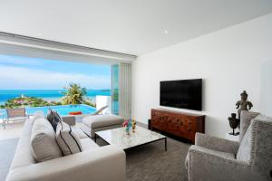 a living room with a couch and a television at Unique Boutique Residences in Bangrak Beach