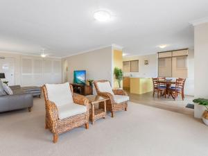 a living room with wicker chairs and a couch at Tradewinds 1 on Kingscliff Beach in Kingscliff