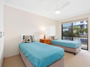 two beds in a room with a balcony at Tradewinds 1 on Kingscliff Beach in Kingscliff