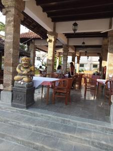 Eine Bärenstatue, die in einem Restaurant an einem Tisch sitzt in der Unterkunft Sari Bunga Hotel - Legian, walking distance to Legian Beach in Legian