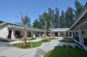 anterior view of a building with trees in the courtyard at Nakara Long Beach Resort - SHA Extra Plus in Ko Lanta