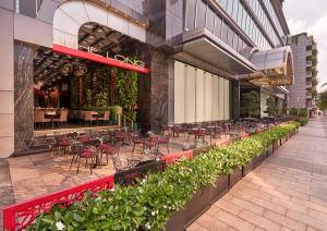 an outdoor patio with tables and chairs and plants at The Reverie Saigon Residential Suites in Ho Chi Minh City