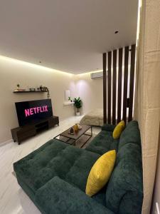 استديو مودرن فاخر - دخول ذاتي في الرياض: غرفة معيشة بها أريكة خضراء وتلفزيون