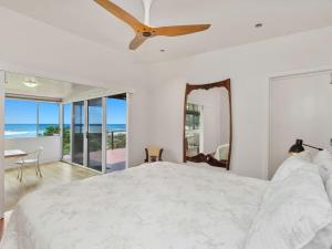a bedroom with a bed and a ceiling fan at The Point - Panoramic Views over Pottsville Creek in Pottsville