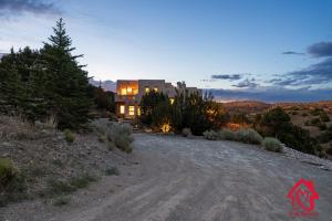 Ein Haus auf einer unbefestigten Straße in der Wüste in der Unterkunft Hillside Haven Retreat - A Placitas Irvie Home in Santa Ana Pueblo