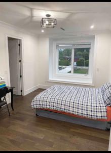 um quarto com uma cama e uma janela em Big and Luxury House em Surrey
