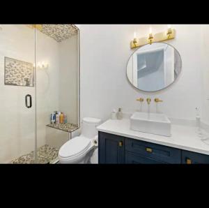 a bathroom with a toilet and a sink and a mirror at Big and Luxury House in Surrey