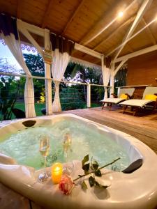 a jacuzzi tub with two wine glasses and candles at Villa Gaïa - Bungalow Ti-Zen et son jacuzzi niché dans un jardin tropical, séjour en amoureux in Le Diamant