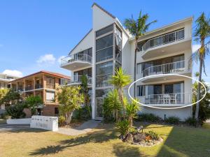 an apartment building with palm trees in front of it at Ocean Outlook on Marine Parade in Kingscliff