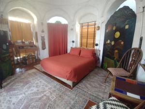a bedroom with a bed with red sheets in a room at La Loma del chivo Llc- Na bolom in Marathon