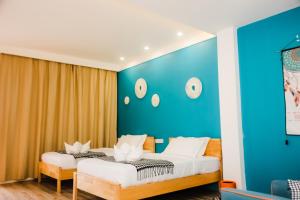 Duas camas num quarto com uma parede azul em Holabay Resort em Panglao