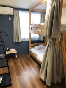 a bedroom with two bunk beds and a ladder at SWELL in Hyuga