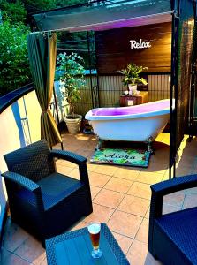 a tub sitting on a patio with a table and chairs at Garden Villa in Fujiyoshida