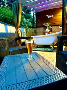 um copo de cerveja sentado numa mesa ao lado de uma banheira em Garden Villa em Fujiyoshida