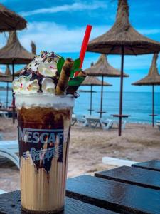 een milkshake bovenop een tafel op een strand bij Joy Apartments in Mangalia